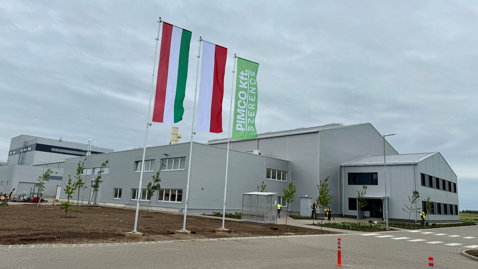 The PIMCO plant building in Szerencs, with a row of flags in front of it